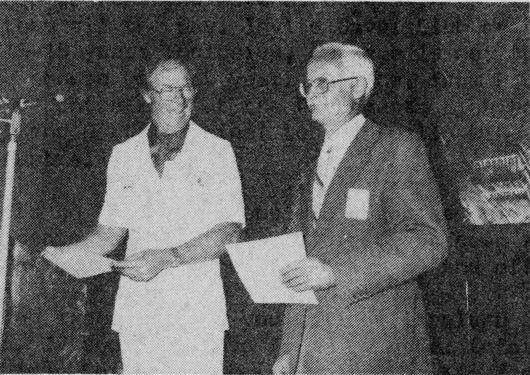 Peter Bell receives the winner’s certificate from Area Governor Leon Taylor who was chief judge of the contest.