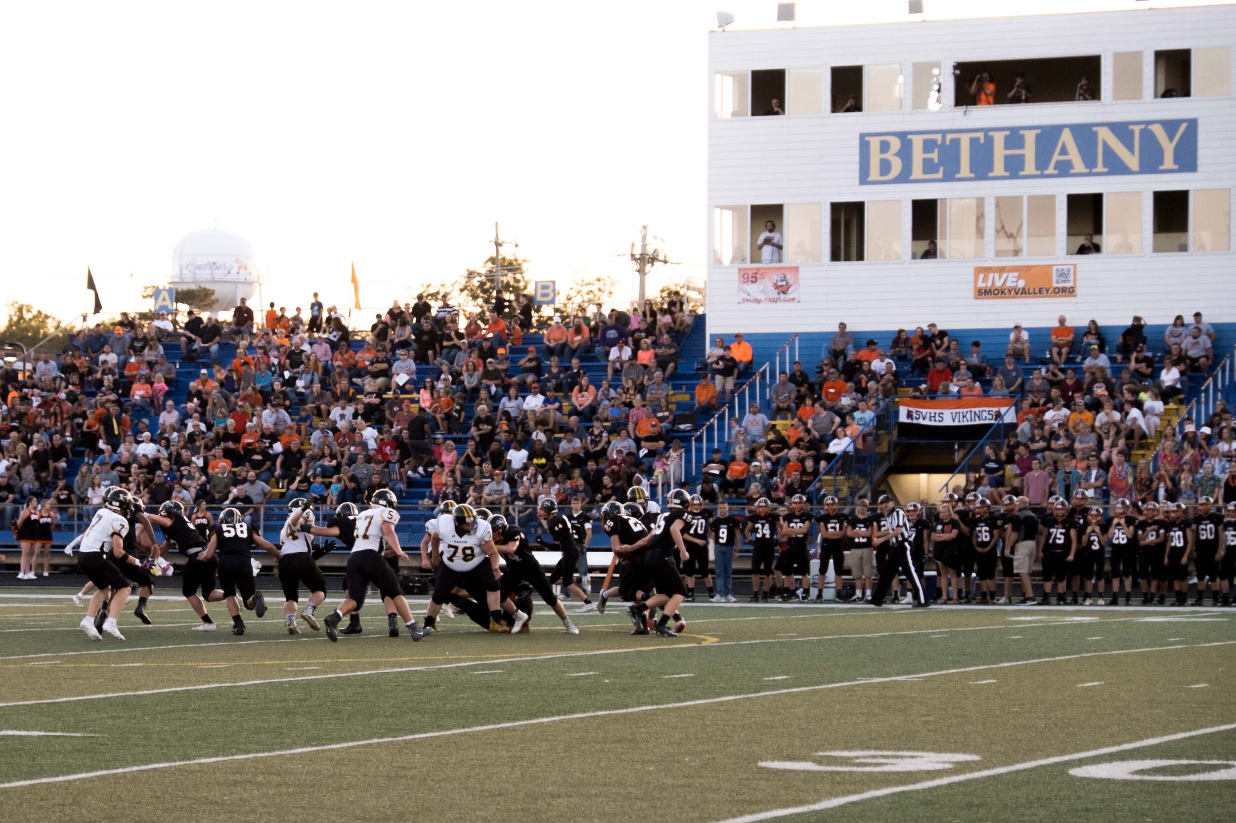 Jr. QB Jake Lucas (15) hands off to Kort Sjogren (25) in the first quarter Friday night at Anderson Stadium in Lindsborg.