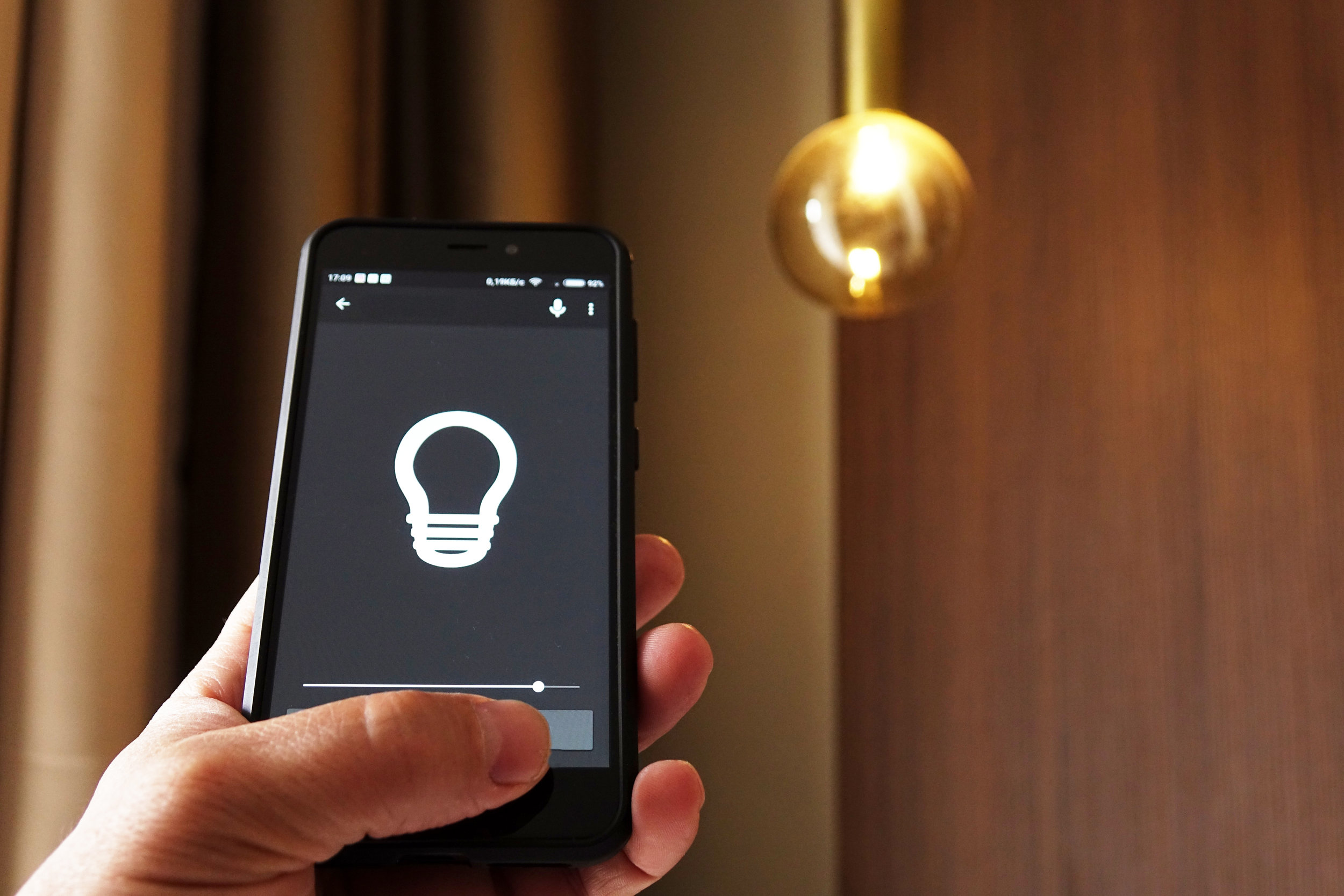 Smart Home: Man Controlling Lights With App On His Phone. electric concept.