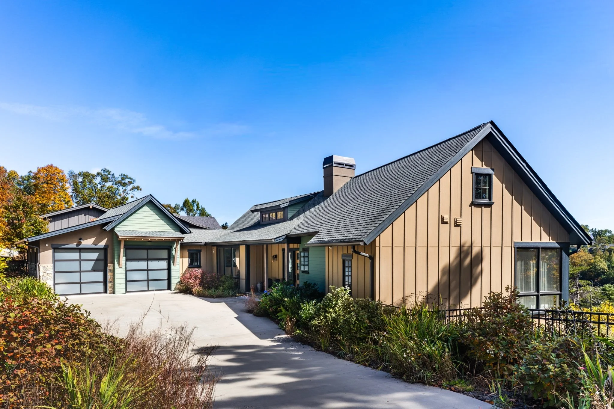 Exterior front view of custom home built by HomeSource Builders in Western North Carolina with board and batten siding and two-car garage