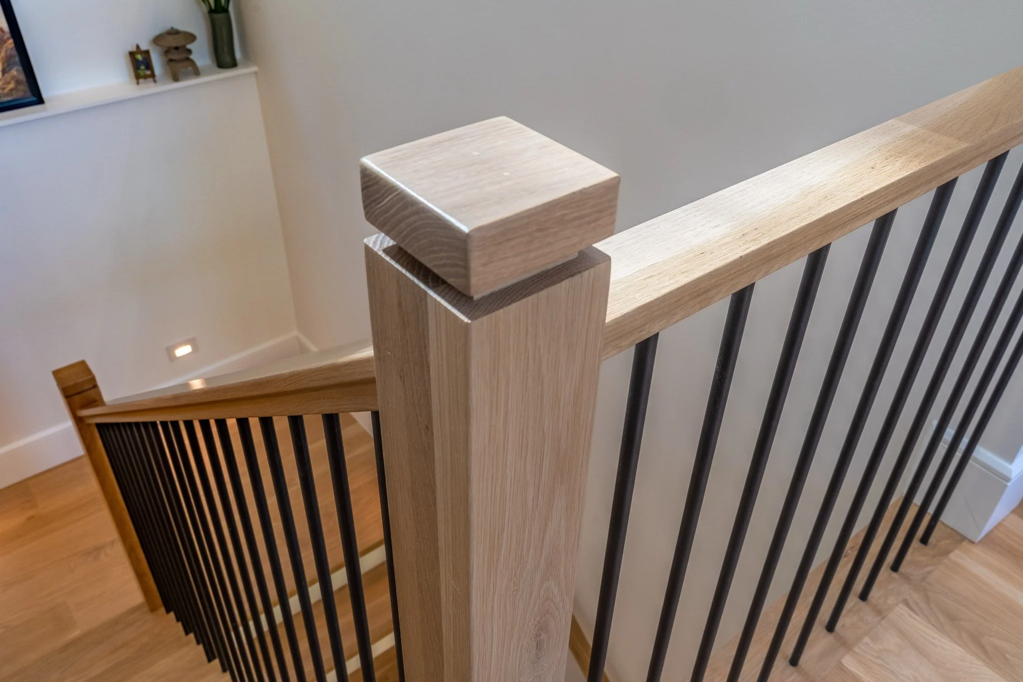 homesource-custom-home-staircase-white-oak-newel-post-black-rod-balusters.jpg