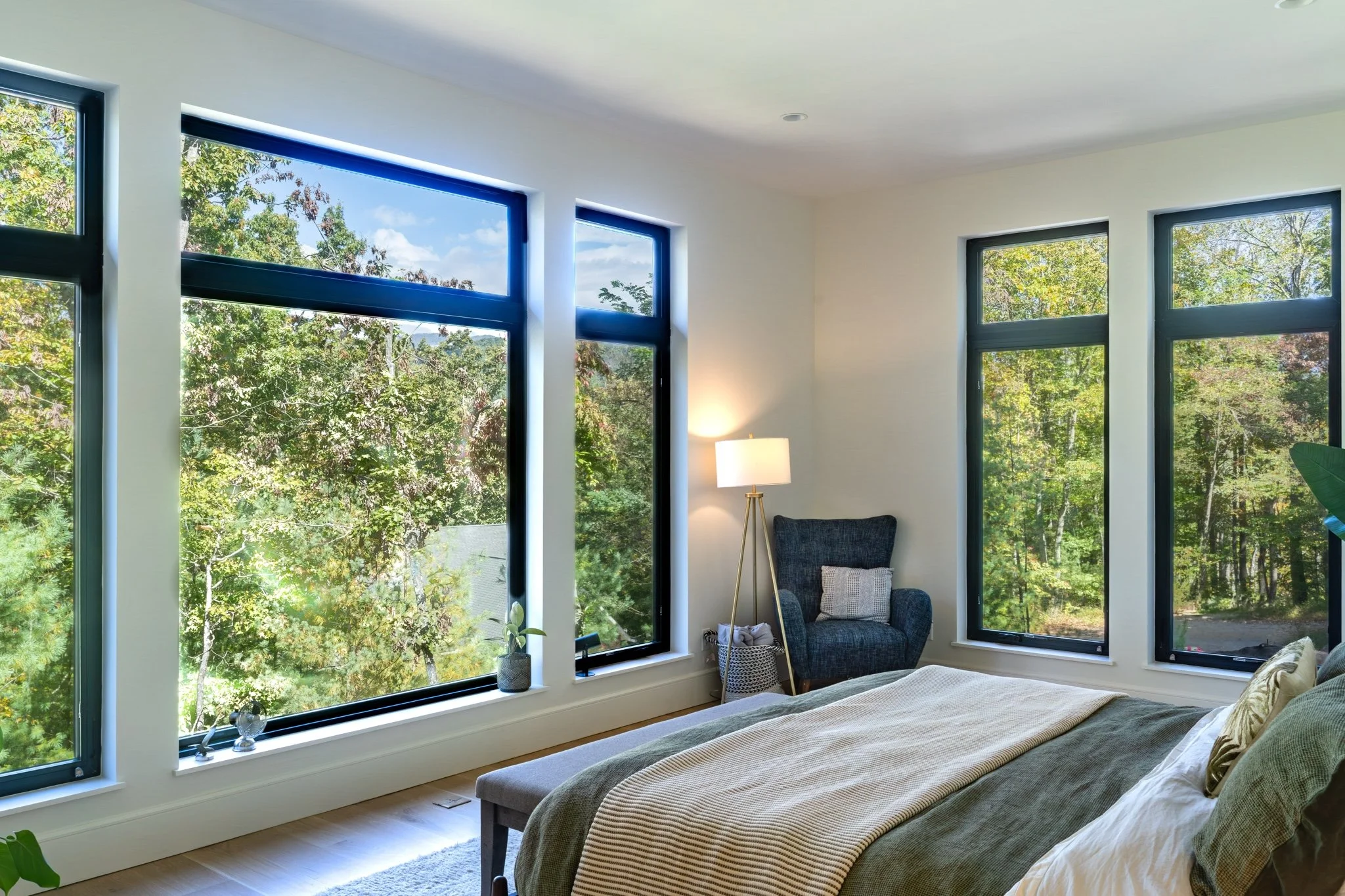 homesource-custom-home-primary-bedroom-floor-to-ceiling-windows-tree-views.jpg