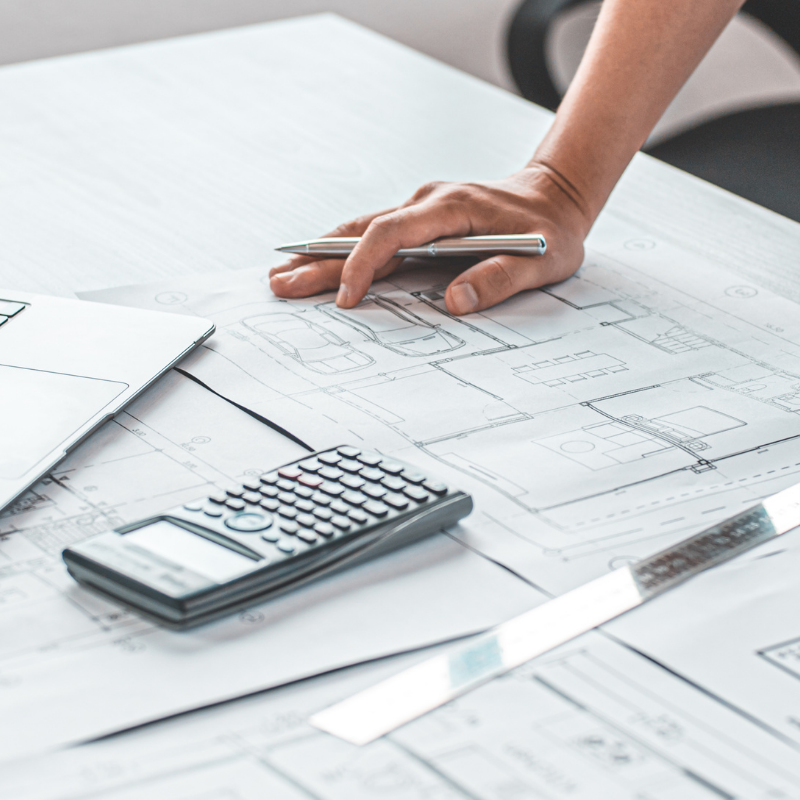 Builder reviewing custom home blueprints with calculator, Asheville NC