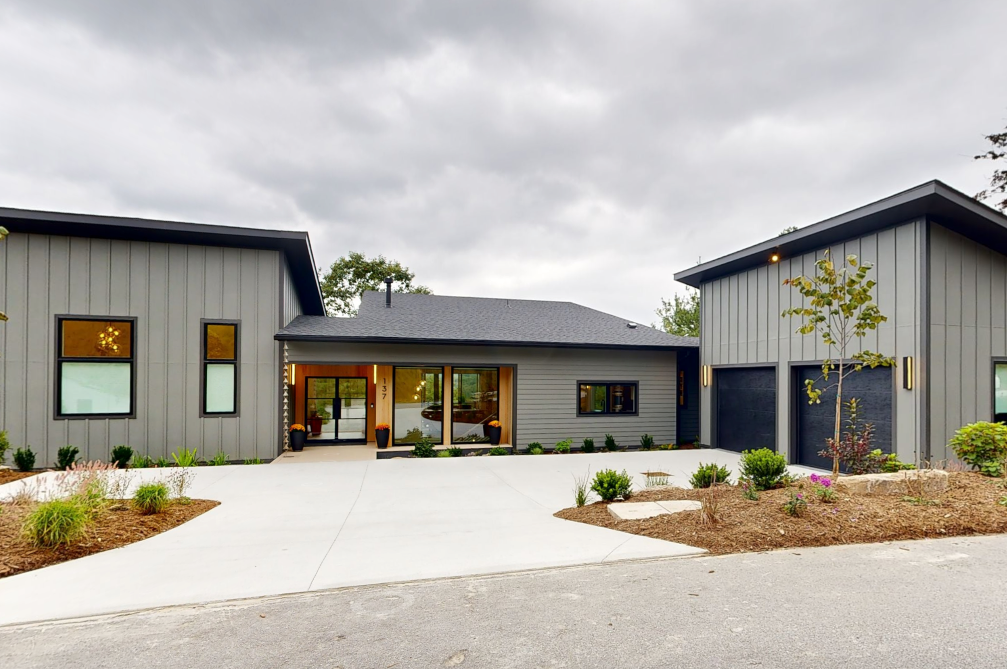 Modern custom home with board and batten siding, black-framed windows, and metal door system, Hendersonville NC