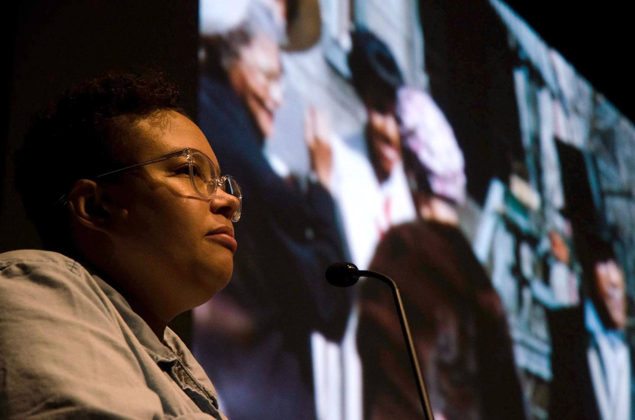 Image: Close-up shot of Candace Ming, who wears a light denim shirt and clear-framed glasses. Candace looks beyond the camera as she shares film selections from the SSHMP archive at the Logan Center Five Year Bash on October 7, 2017. Photo by Martin Awano, Film still from the Jean Patton Collection, courtesy of the South Side Home Movie Project.