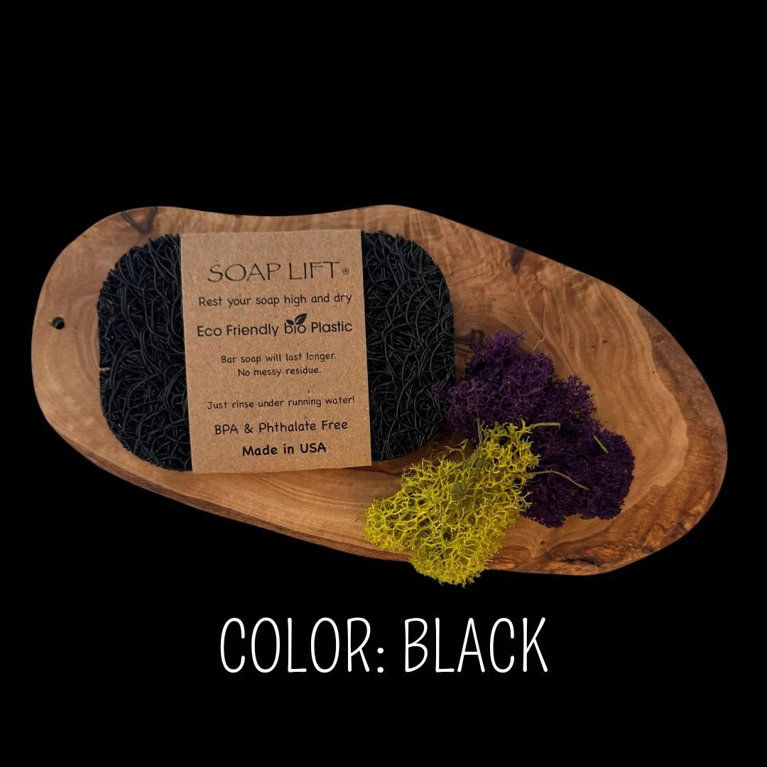 Black Soap Lift eco-friendly bio plastic soap dish on a dark rustic wood surface