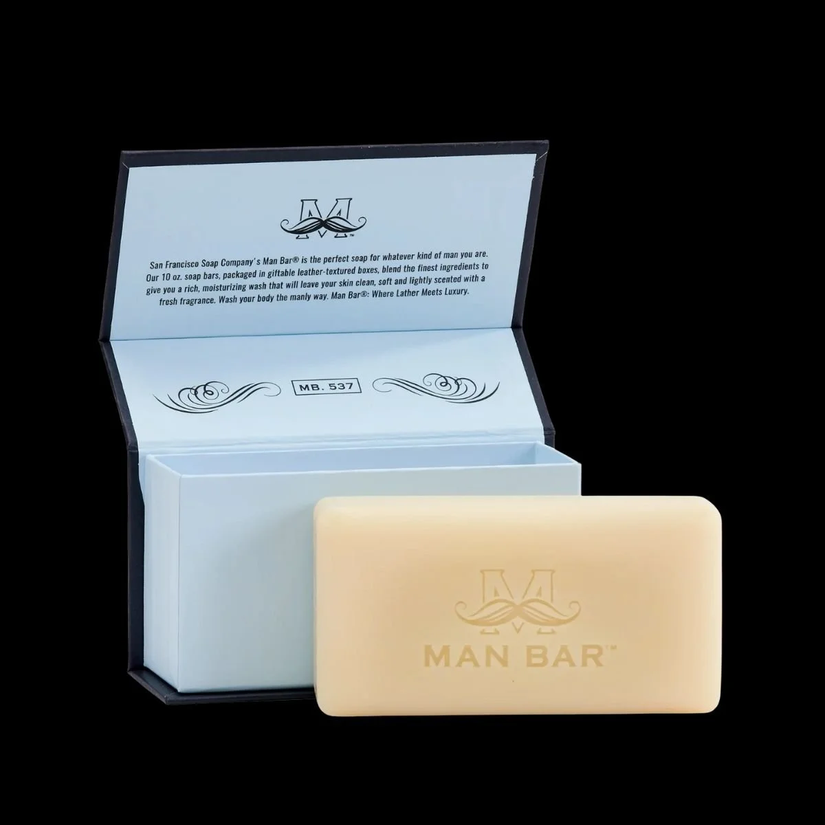 Man Bar Soap MB.537 Deep Cleansing Silver Sage and Bergamot 10oz bar removed from open navy blue leather-textured gift box with light blue interior, showing embossed Man Bar logo on cream-colored soap