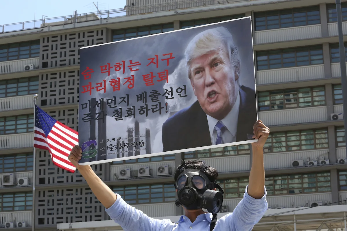 A South Korean environmental activist wearing a gas mask participates in a protest to denounce the U.S. withdrawal from the Paris climate accord, in front of the U.S. Embassy in Seoul, South Korea, Monday, June 5, 2017. The sings read " A breathtaki…