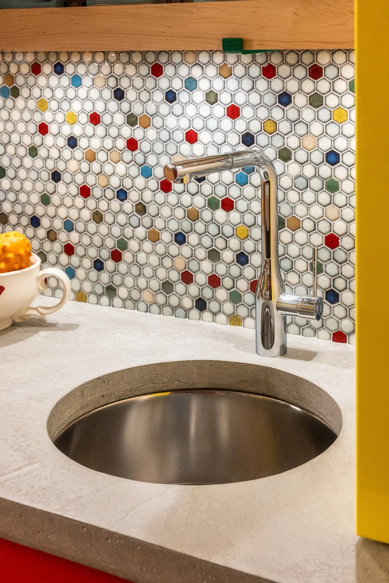 Prep sink with Grohe faucet, concrete countertop, and colorful tile backsplash.