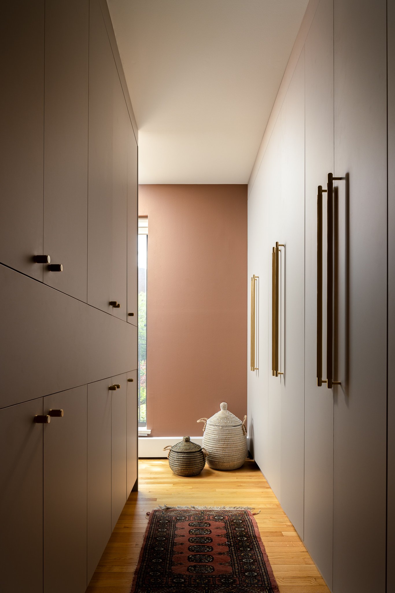 Primary suite dressing area with floor-to-ceiling custom wardrobes and brass hardware in Society Hill Philadelphia townhome