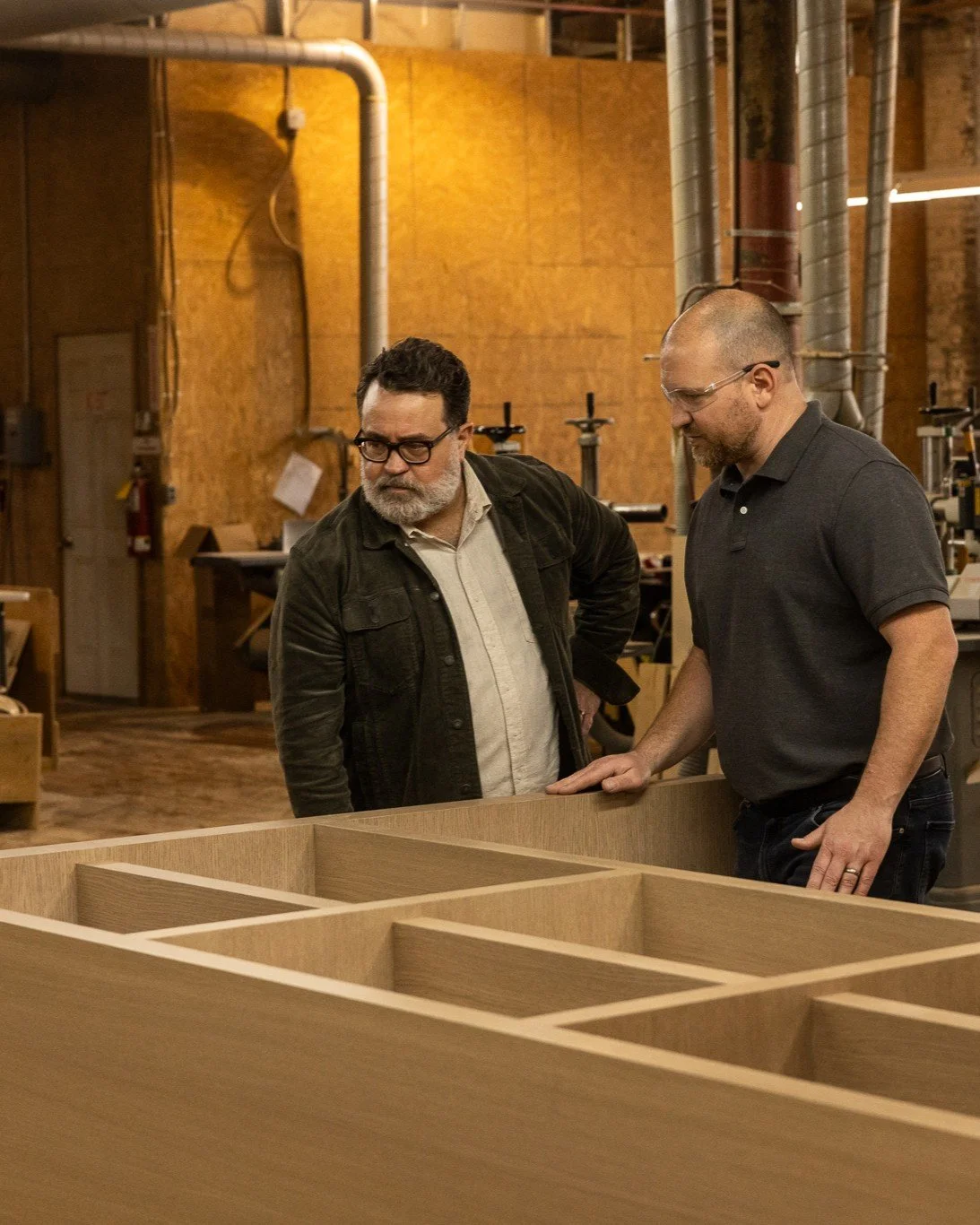 J.THOM founder Jason Thompson reviews custom cabinetry construction with a manufacturing partner to ensure design and production alignment.