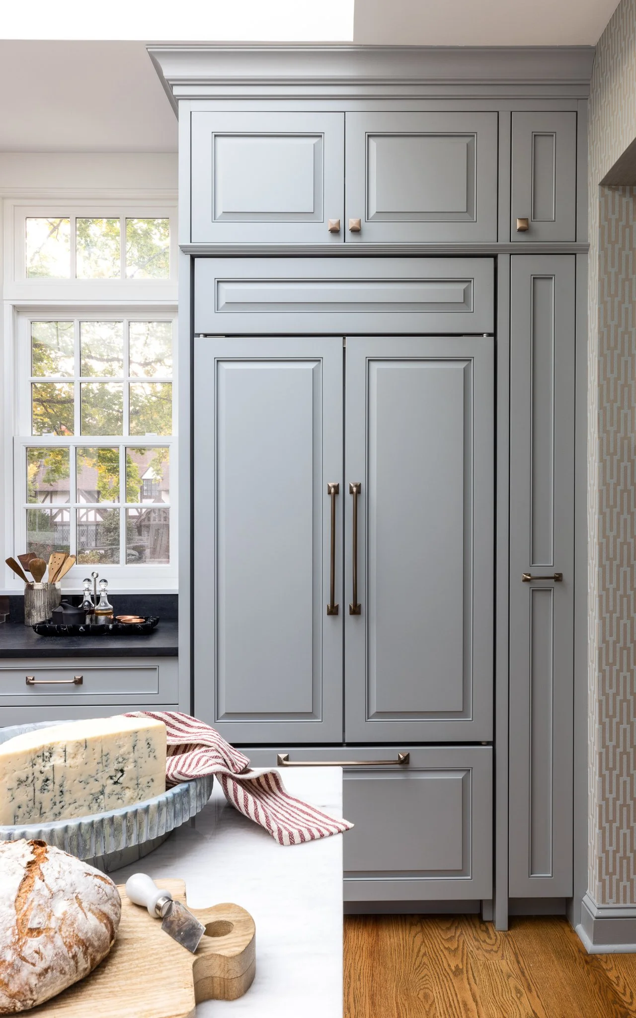 Kitchen remodel in Wynnewood PA with J.THOM Signature custom cabinetry inset door style French blue painted finish integrated refrigerator panels brass hardware and crown molding