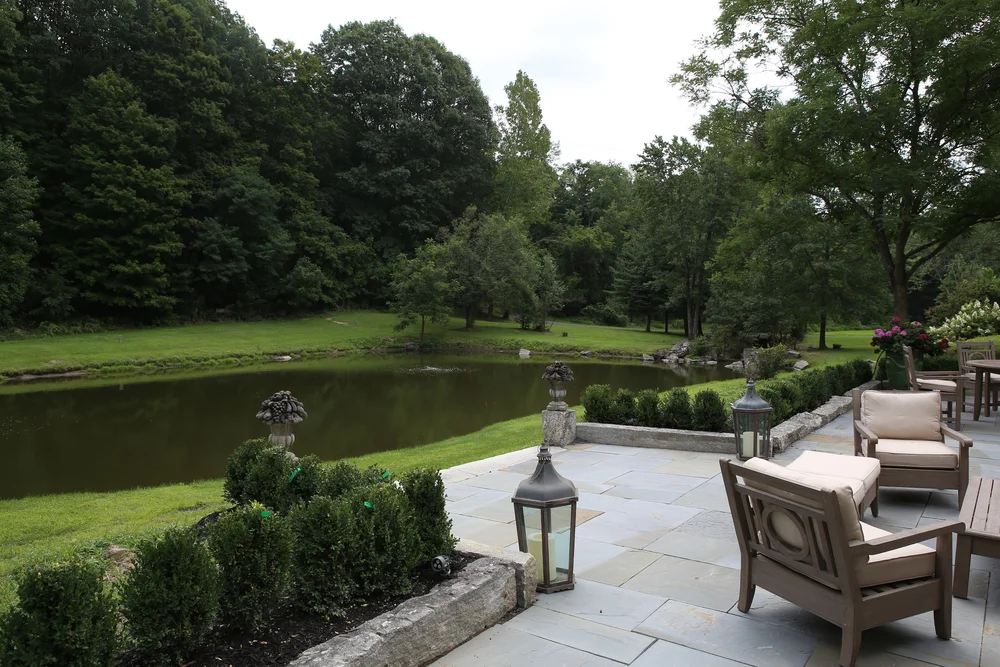 The pond terrace with stone urns and boxwoods