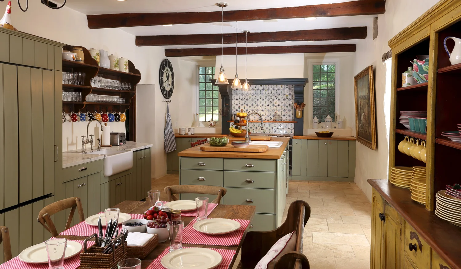 The country chef's kitchen with sage-green cabinetry, marble and butcher-block counters, and a generous island