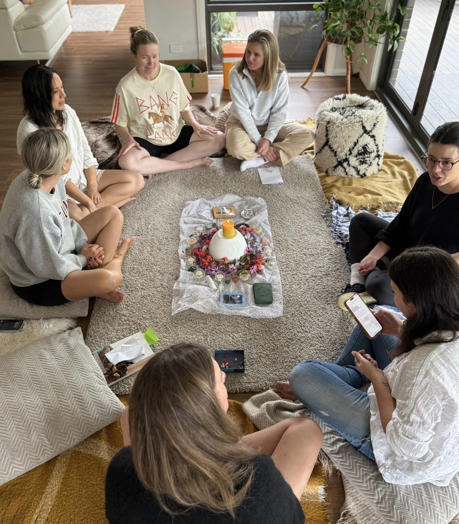 Mothers' Circles. Community, ritual, honouring the seasons, being surrounded by beauty. Group of women sitting in a circle on the floor, engaged in a ritual or spiritual activity, with candles, flowers. Eastern Suburbs, Bronte, Sydney