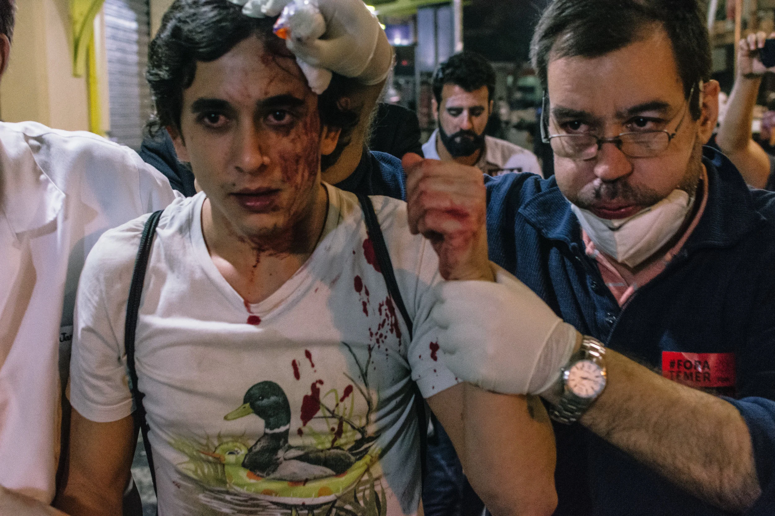 Volunteer medics lead a man injured during protests to an ad-hoc casualty collection area.