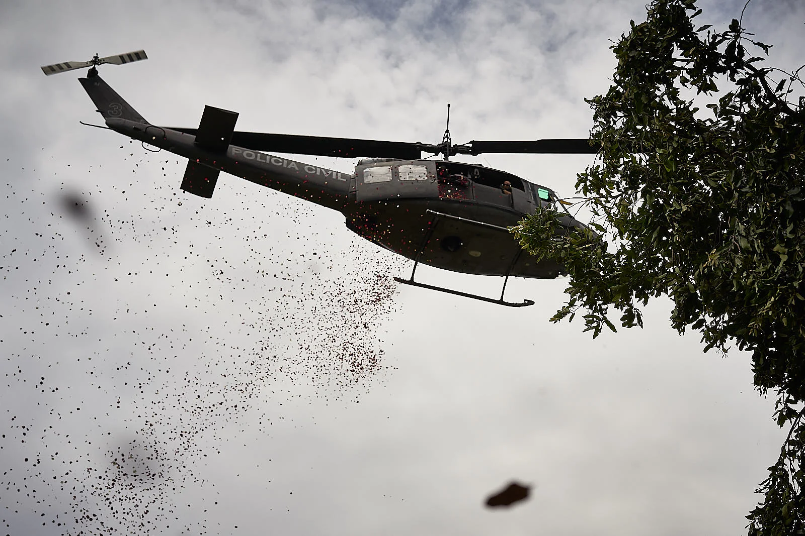 A helicopter from the Civil Police drops flowers on the funeral of Delegado Fabio Monteiro, a police officer executed by criminals. Residents of Jacarezinho say that police used the helicopter to shoot indiscriminately into the community as retaliation. (Photo C.H. Gardiner)