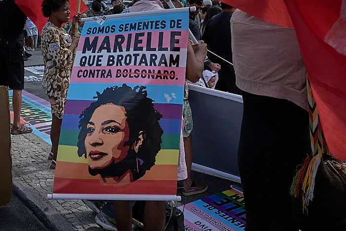 A protestor against police violence holds a sign with Marielle Franco’s face (Photo: C.H. Gardiner)