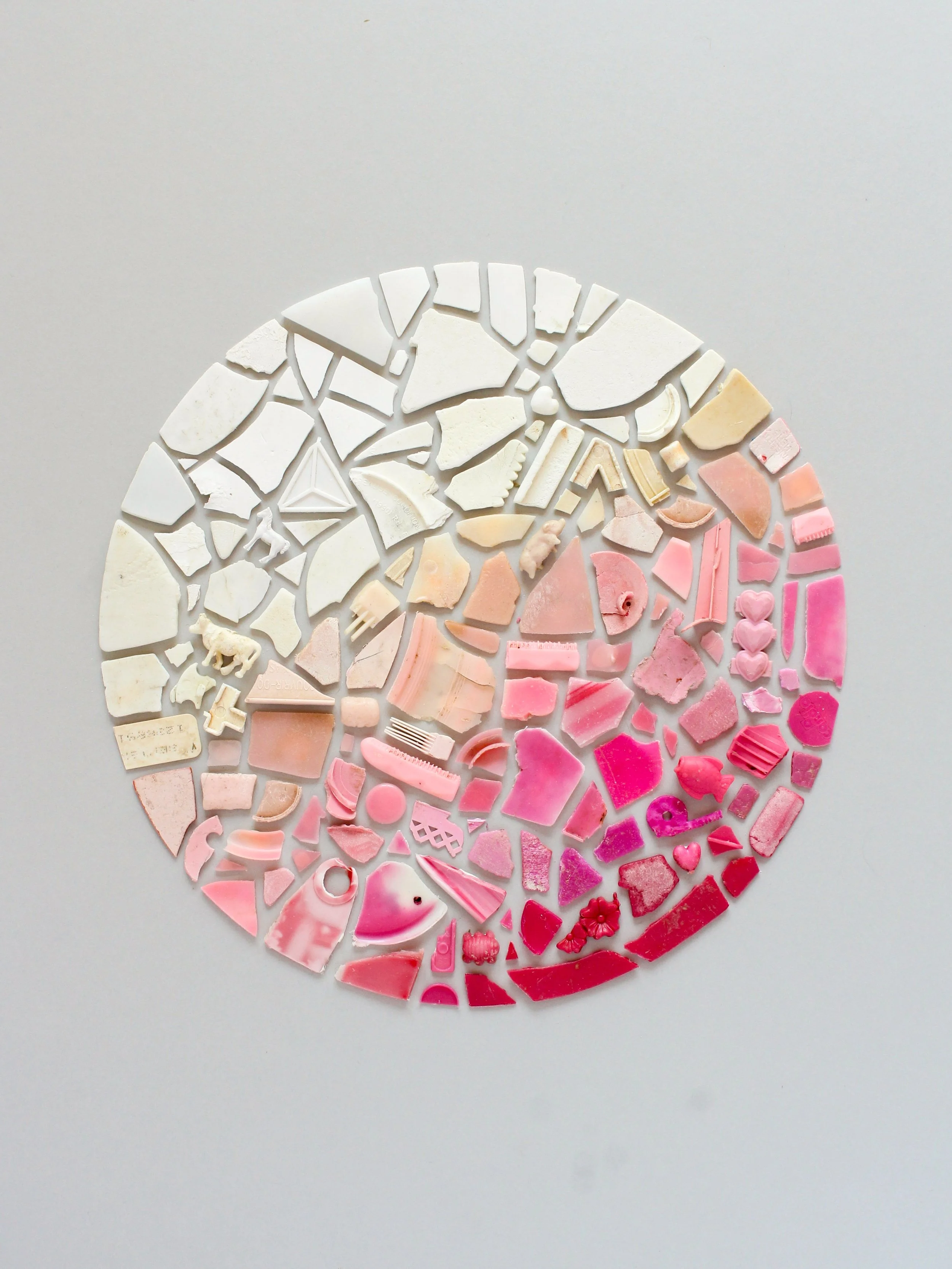  A gradient of red, pink and white beach plastic 