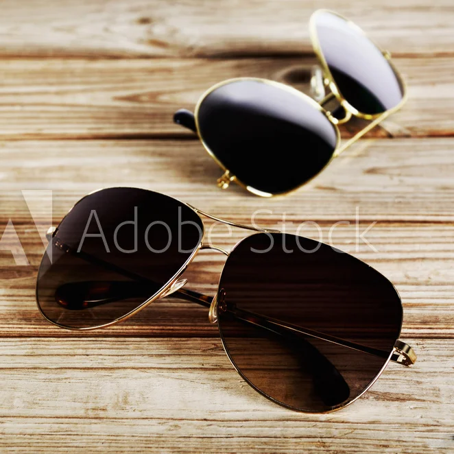 twounisexsunglassesclose-uponawoodenbackgroundtopview.jpg