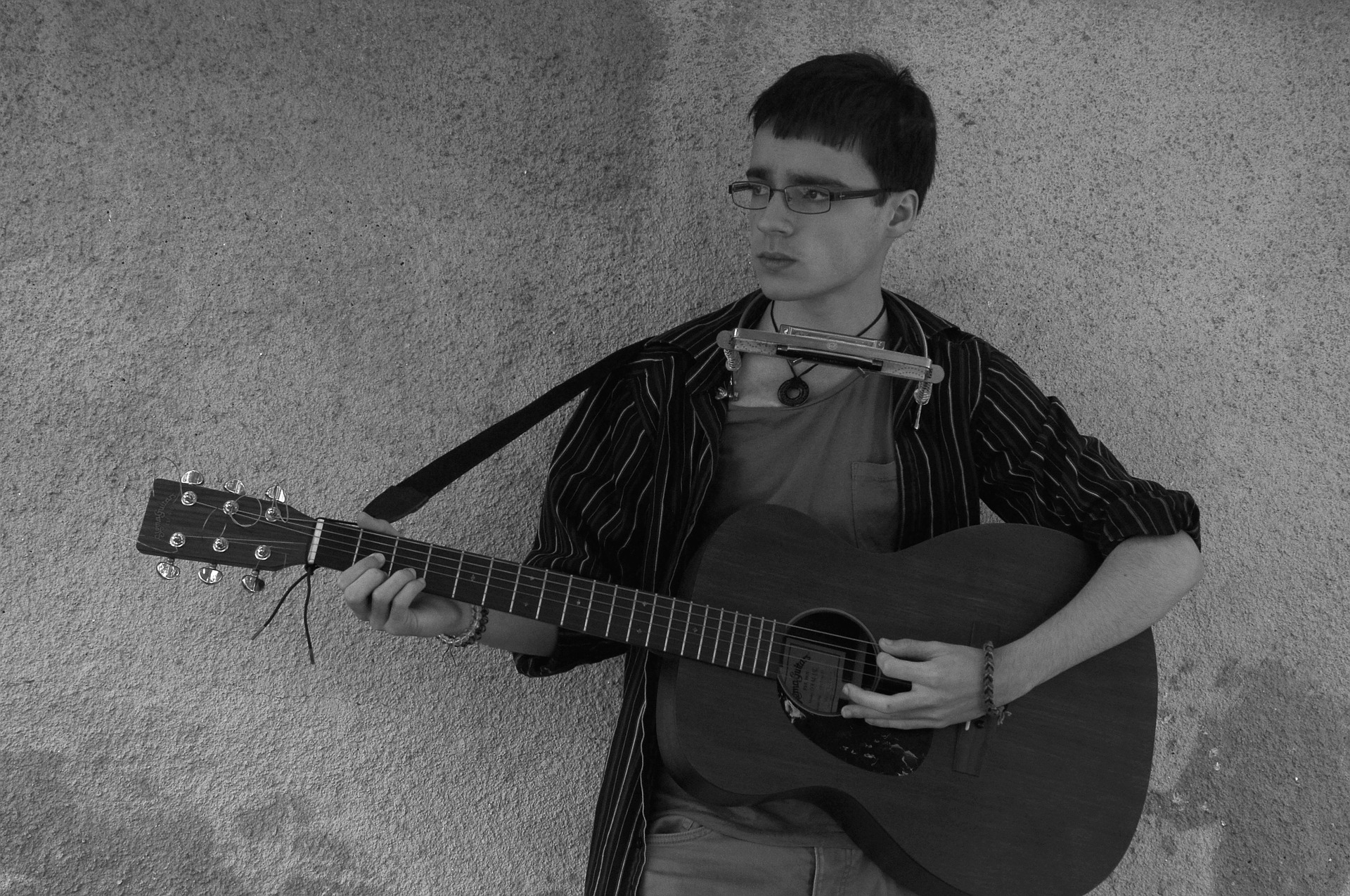 This guitarist has his harmonica on a neck stand so that he can play both instruments at the same time.