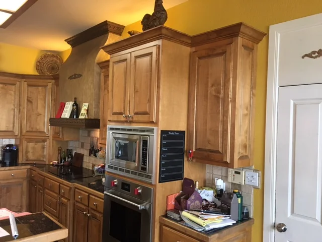 Before: Dark stained cabinets, tumbled marble backsplash, black tile countertops 
