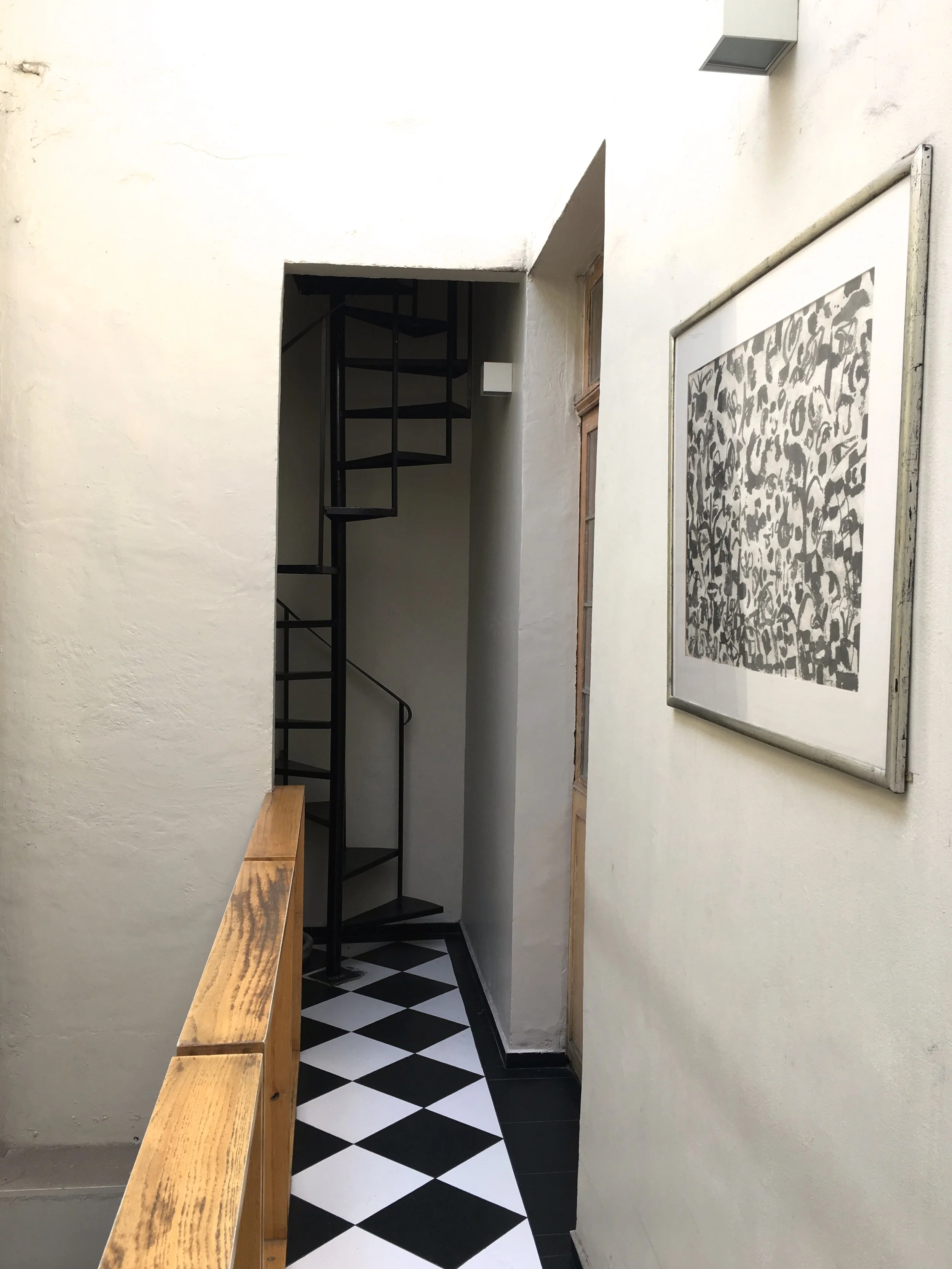 Black and white catwalk with a winding staircase leading to the balcony. 