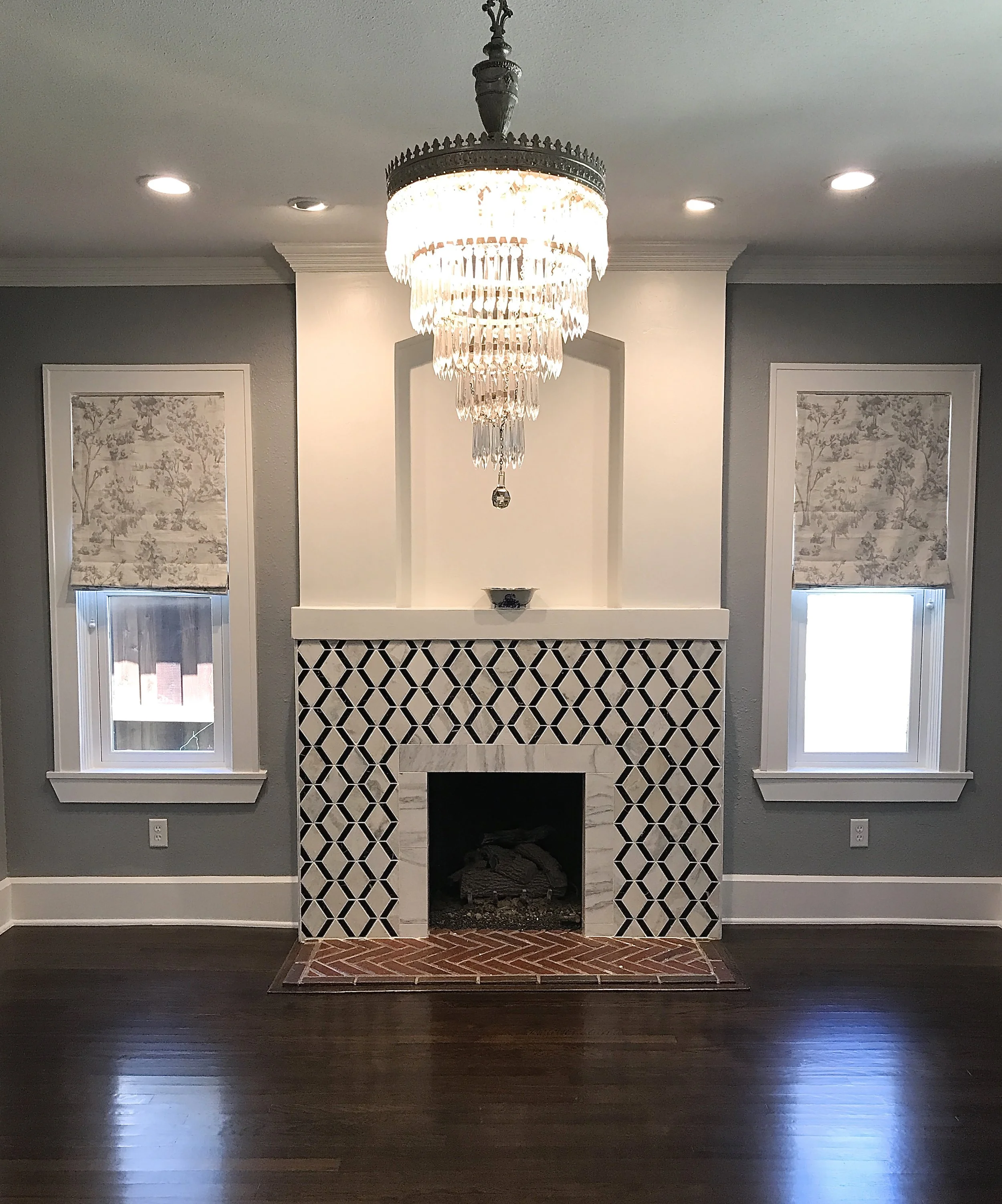 Geometric black and white wall tile surrounding the hearth 