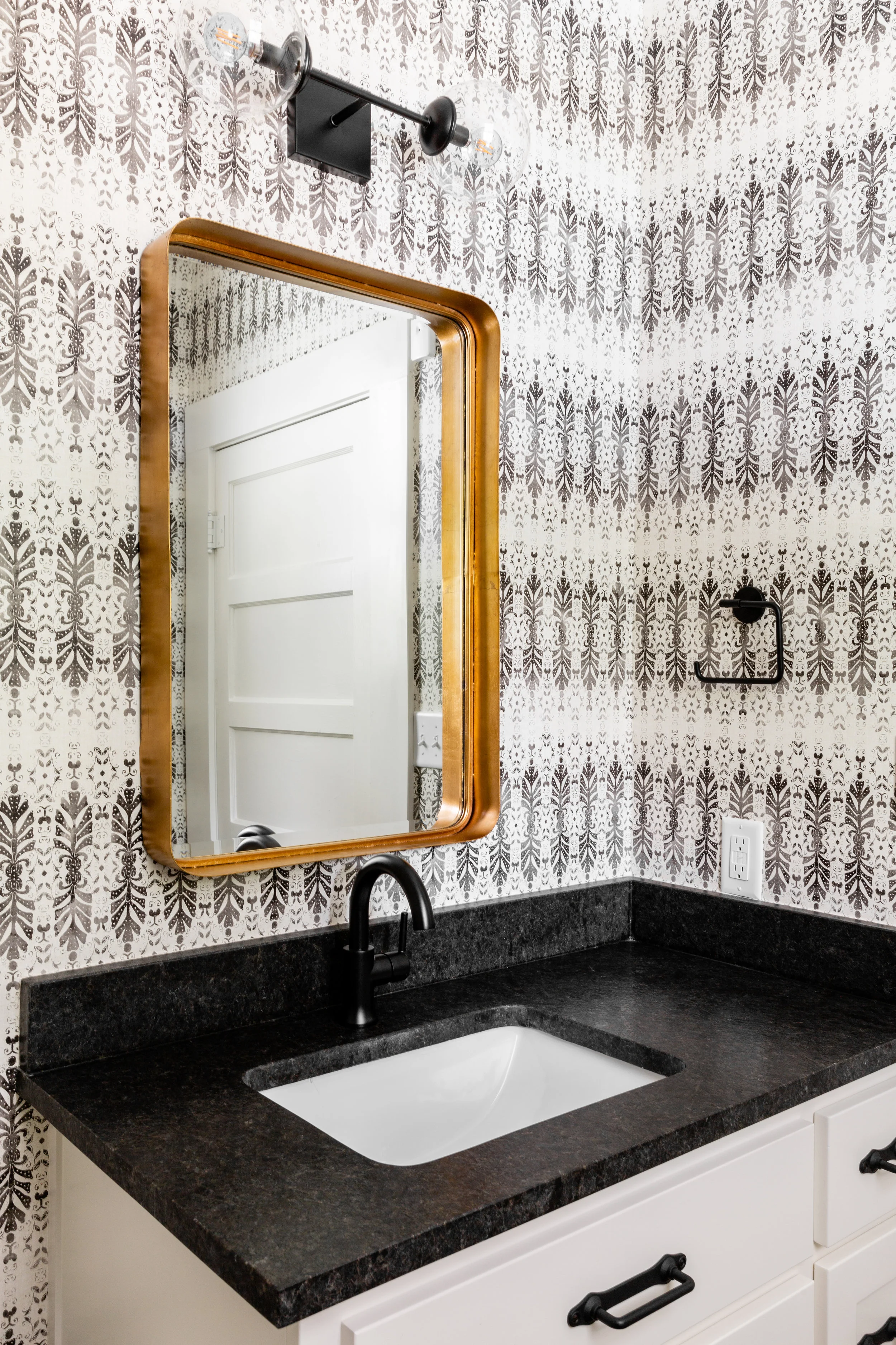 Mixed metals is something we should all embrace! I love how this brass mirror by Uttermost stands out against all the black & white. We went for a leathered black granite countertop for extra durability.