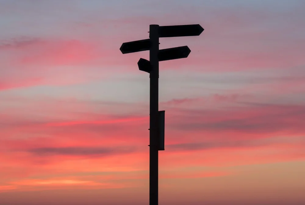 Silhouetted crossroads with several directional signs. Source: Unsplash