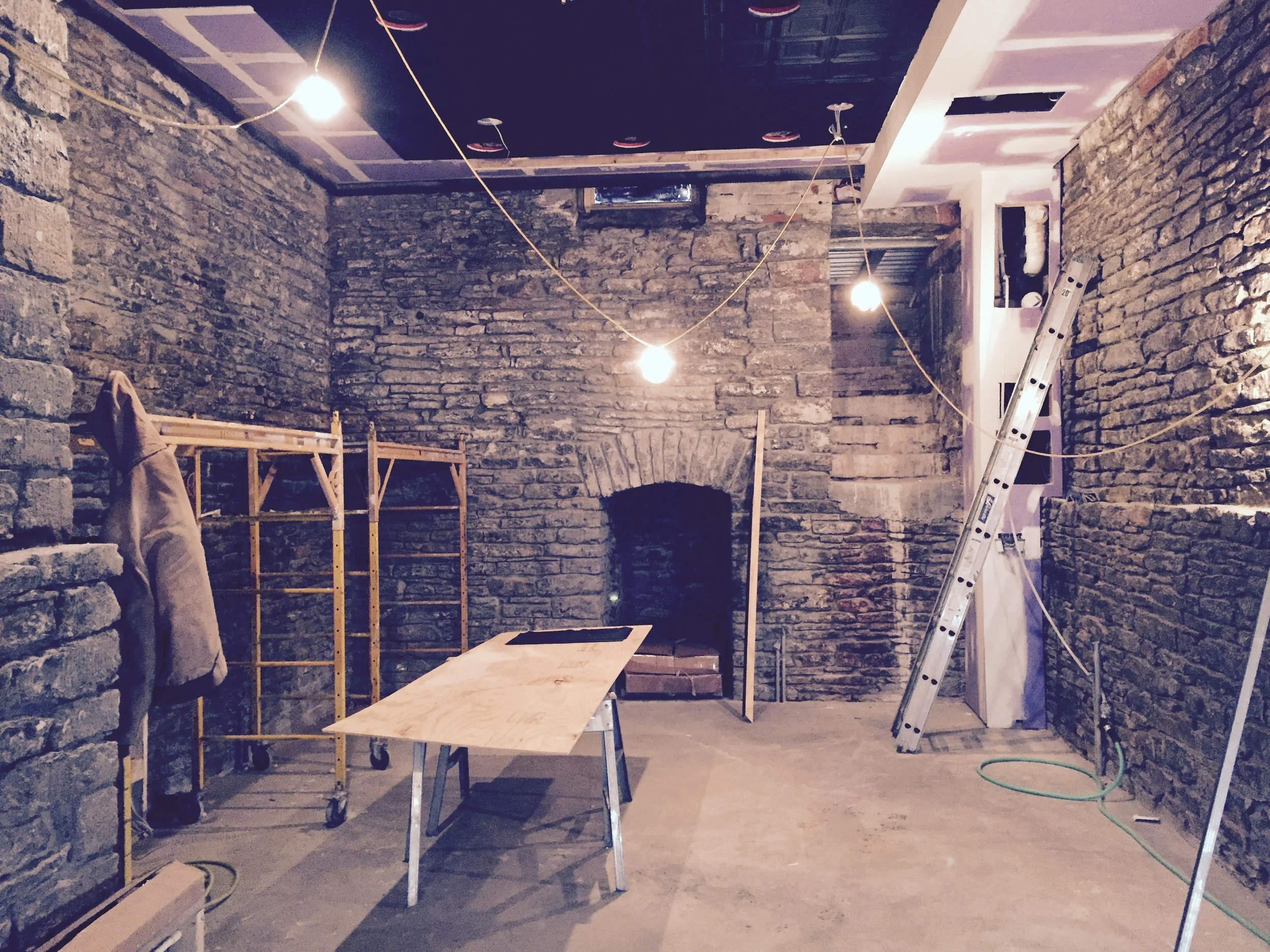 The original wood joists were removed in the basement to open up the space. The original fieldstone foundation walls were stabilized and sealed to make a basement theater space.