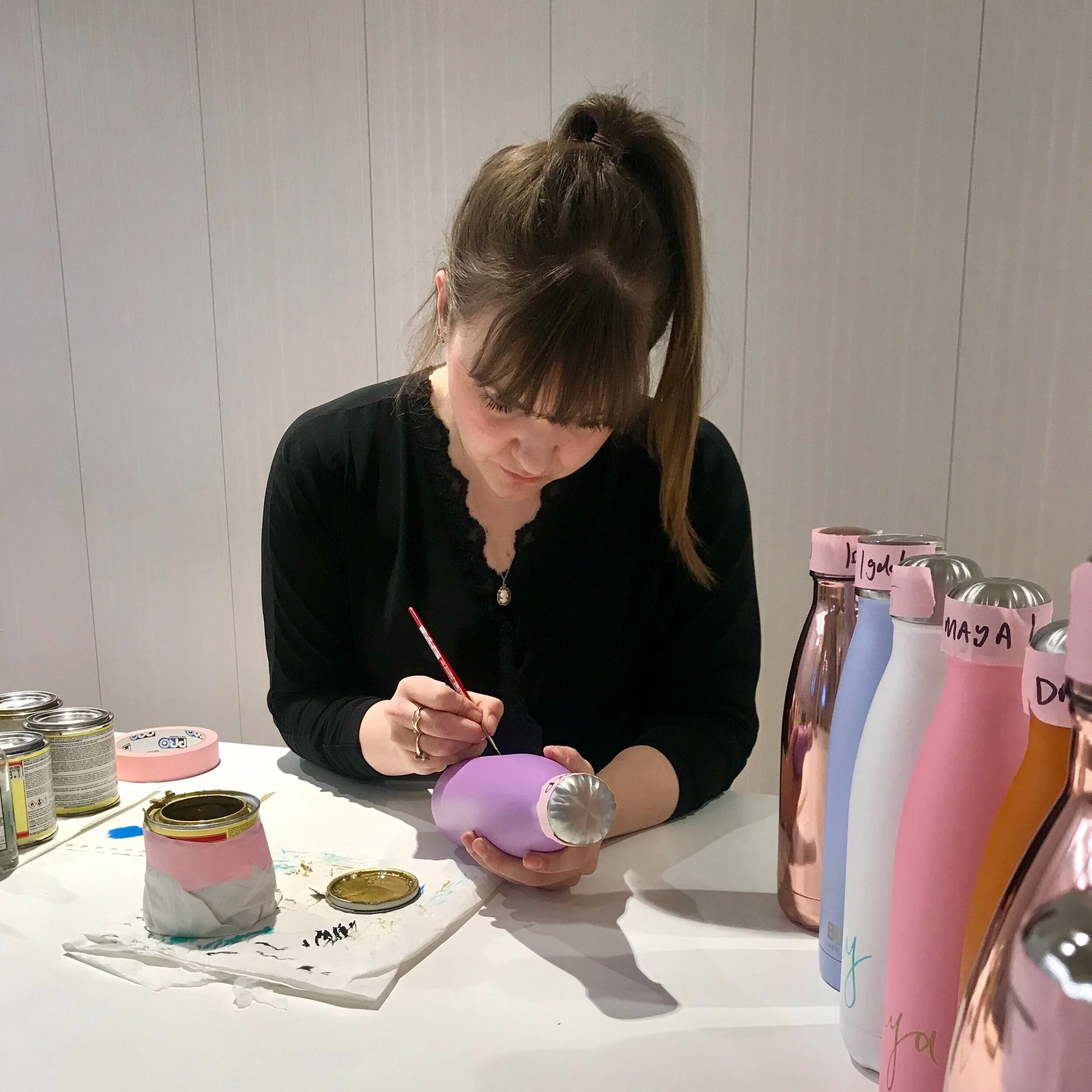 Louie lettering a refillable bottle in ASOS HQ