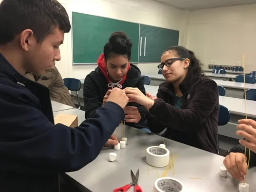 Brandon D. from Madison Park Technical Vocational School assisting his peers in STEM programming at Sociedad Latina.