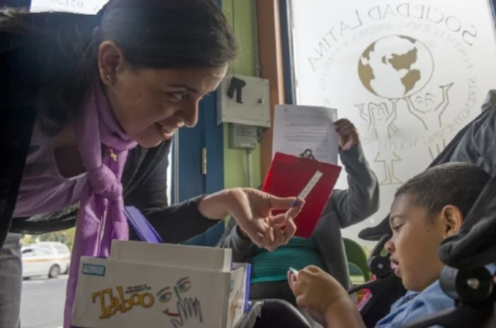 Andrea C., one of our staff who has been working closely with newcomer families entertains children as parents register their children in Boston Public Schools.