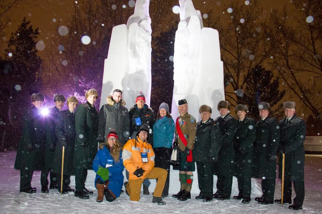 Photographed in front of the monument, after the ceremony is President of the Silver Skate Festival Society - Mr. Harm de Groot (at centre with red toque), on either side of him is Edmonton Mayor - Don Iveson and provincial Minister of Seniors - MLA Lori Sigurdson. On bended knee are the creative and well-known artists, Brian McArthur and Dawn Detarando. Members of The Loyal Edmonton Regiment are also in attendance having supported the event by way of a piper, singer, speaker and vigil party. Photo by Grant Cree.