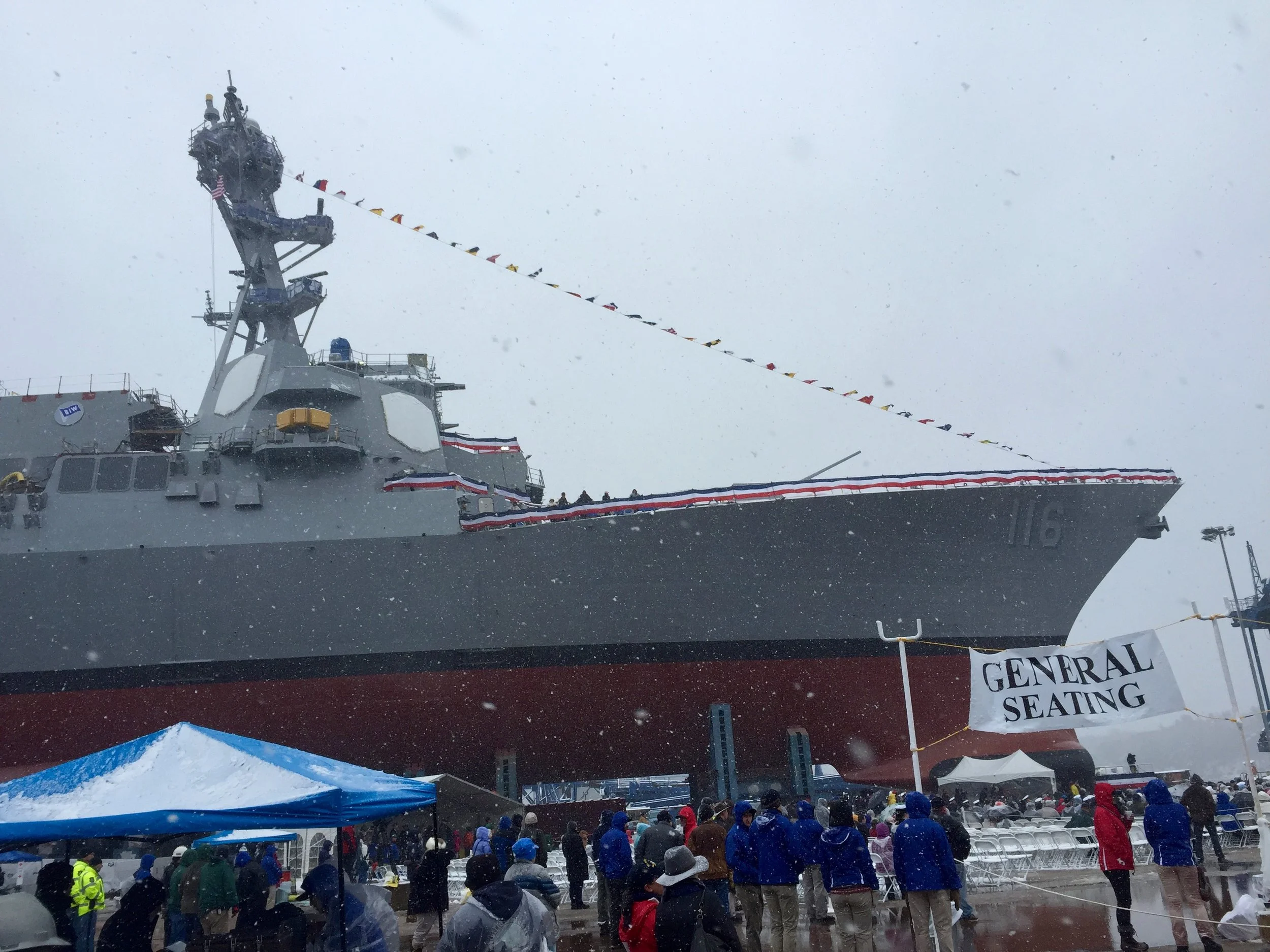 Snow swirls around the future USS Thomas Hudner at its christening at the Bath Iron Works shipyard in Bath, Maine. Photo by Rick Holmes