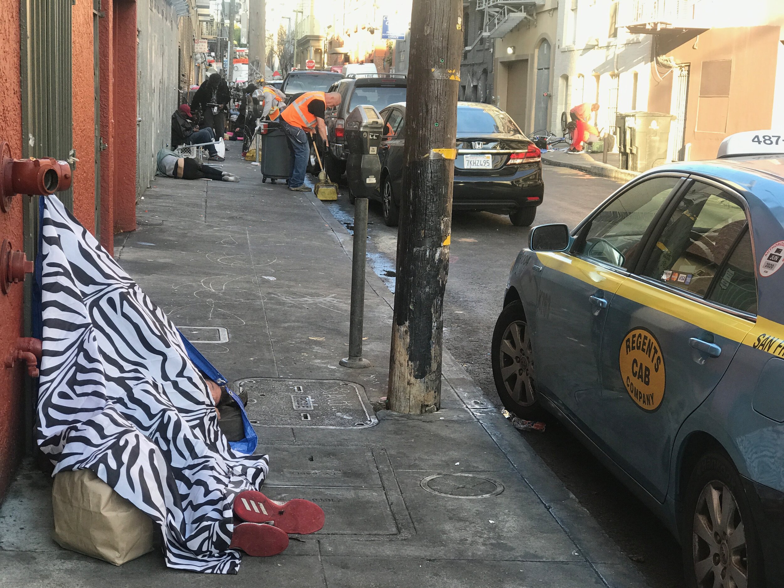  City workers carefully clean up sidewalks in the Tenderloin without disturbing sleeping homeless people. For a century, the Tenderloin has been a haven for the down-and-out. 