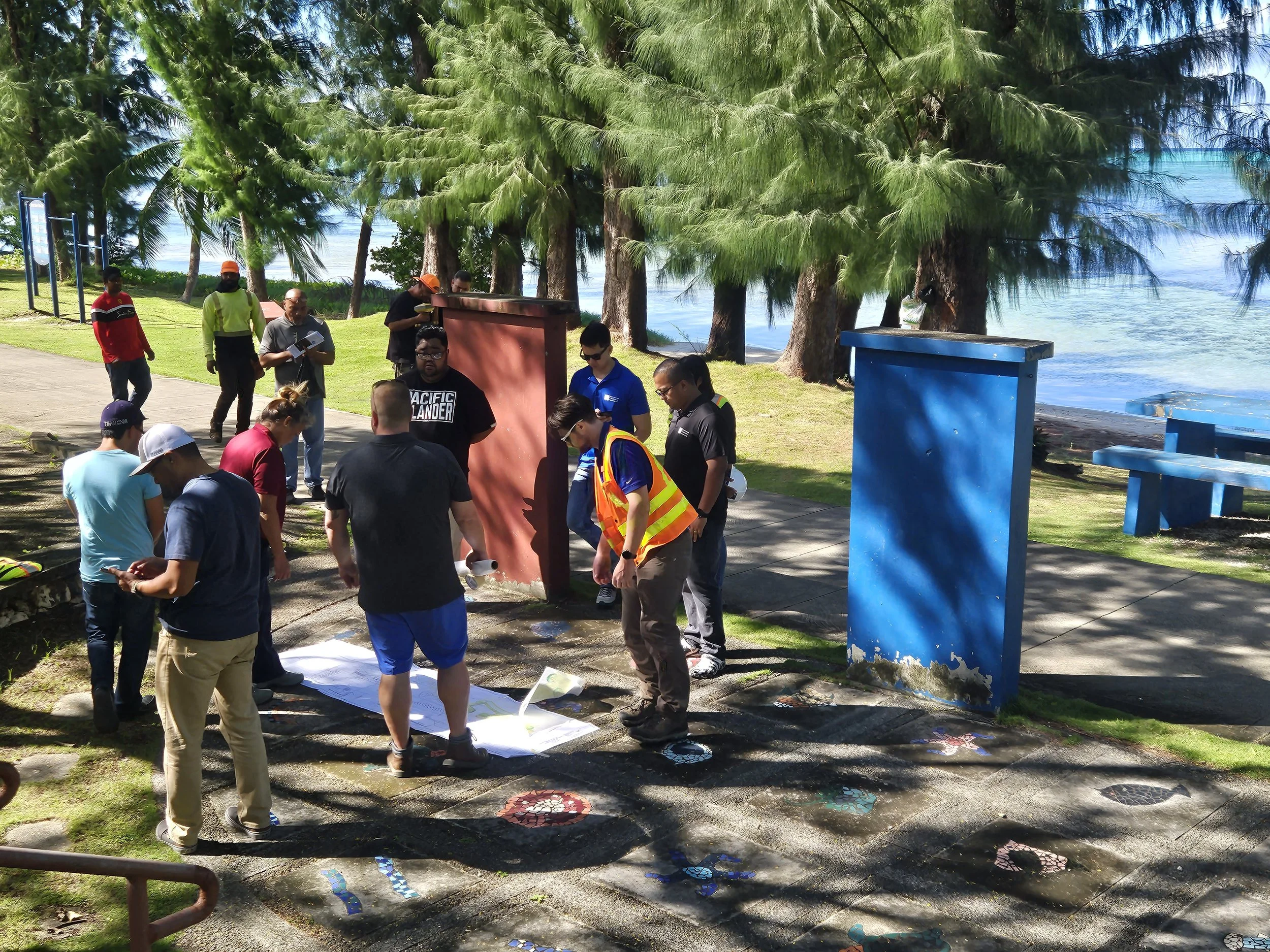 The Beach Road Pathway Corridor Advisory Committee and personnel from CNMI BECQ gather on-site to review draft designs and permit plans.