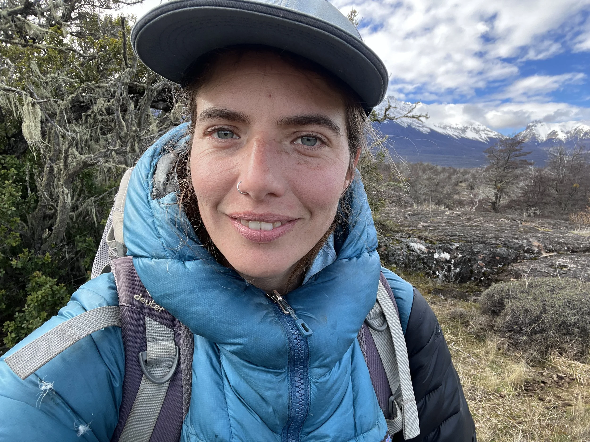 Woman hiking outdoors in Patagonia, smiling in a steppe landscape