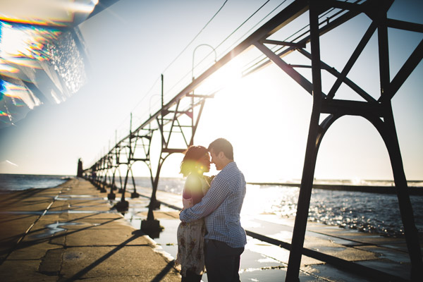 couple touching head to head on pier, backlight, golden hour sun, intimate connection