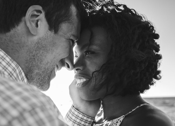 man embraces wife in his arm, foreheads touching, black and white 