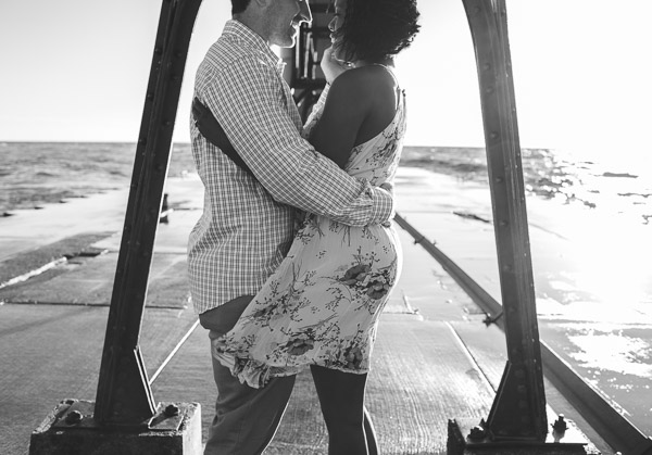 documentary shot of couple dancing on pier, black and white 