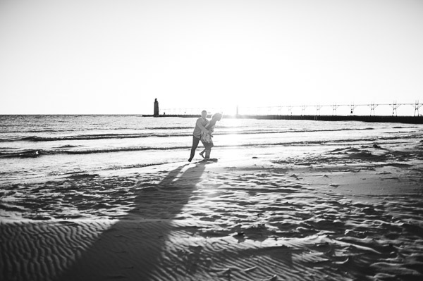 couple embracing on beach in glow of sun, black and white 