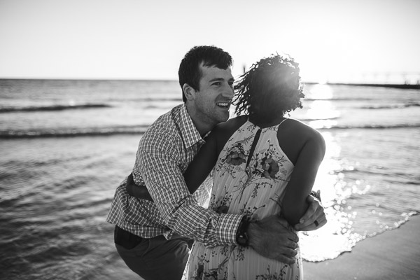playful embrace of couple on beach, black and white 
