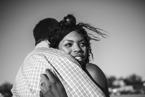 close-up side portrait of woman in embrace with her husband on the beach, black and white 