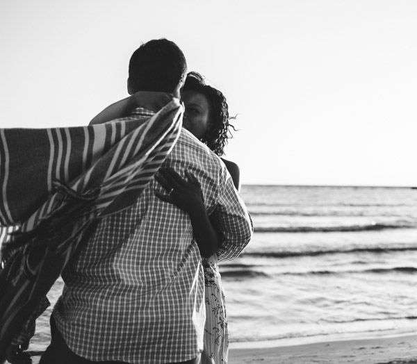 documentary image of couple embracing on beach, movement, connection
