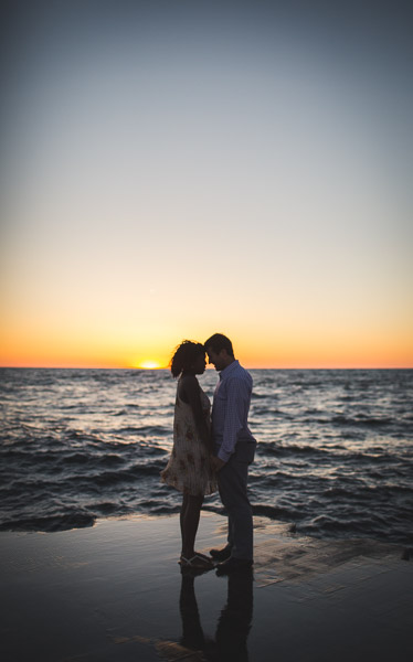 silhouette of couple touching foreheads on pier