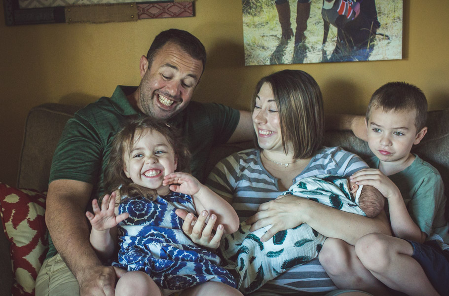 Family giggles full of joy on couch 