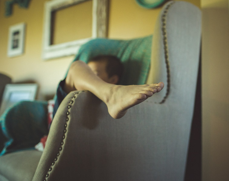 detail image of boy's foot draped over chair 