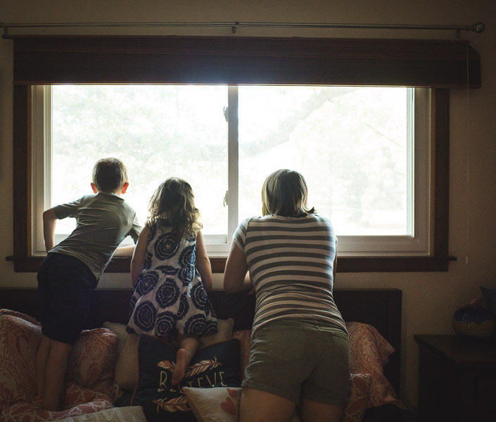 family reflecting out large window in bedroom 